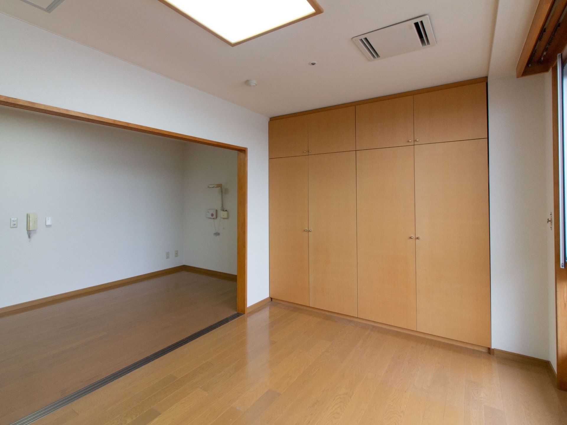 2ルームの居室である。一つの部屋には壁に収納が建てつけられている。二間続きで広々として、開放感のある室内である。