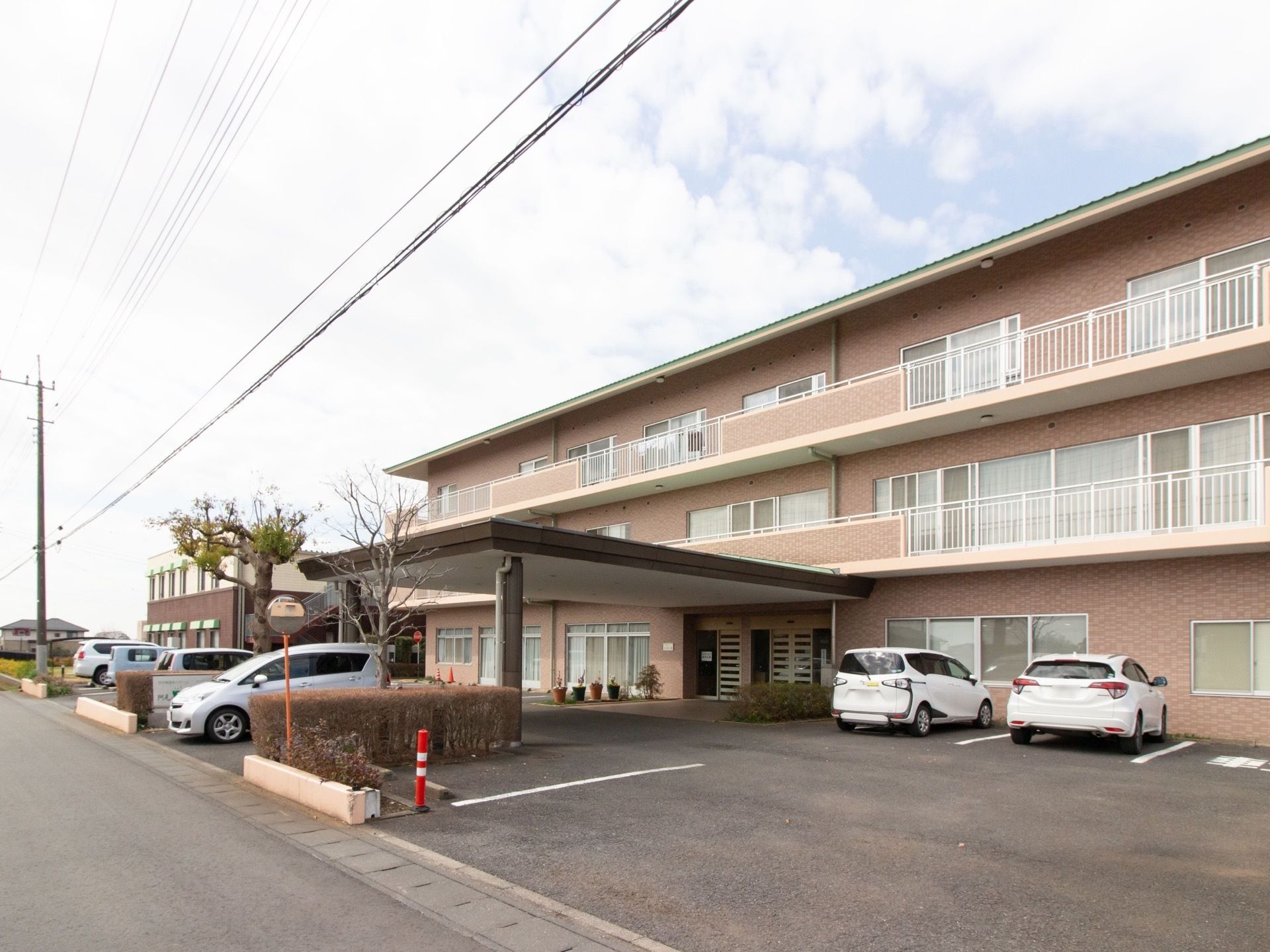 3階建ての施設は外壁がブロック調のスタイリッシュな外観である。敷地内には広々とした駐車場が完備されている。