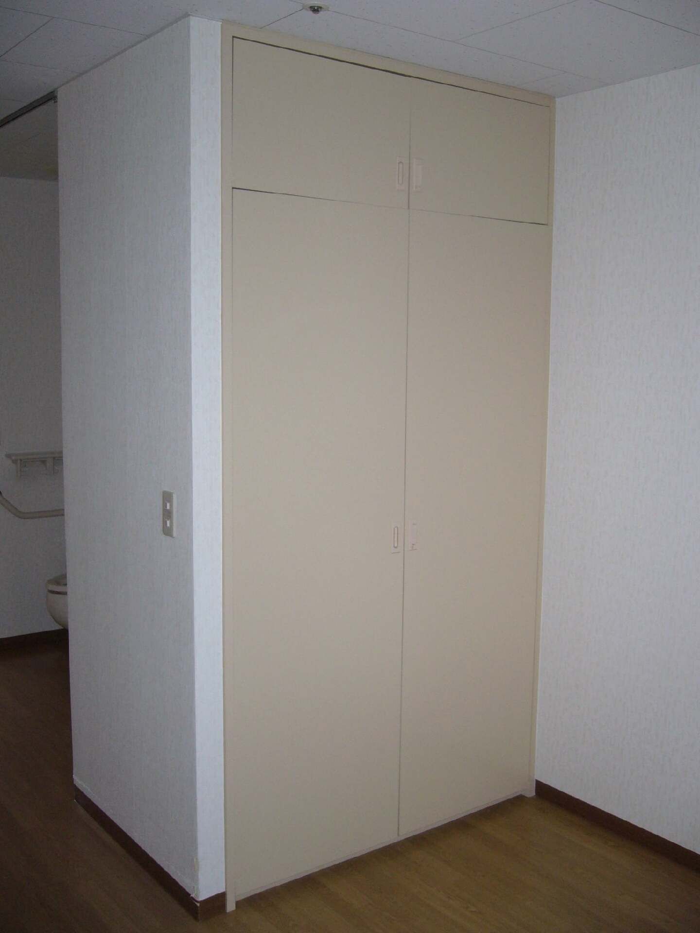 取っ手のないシンプルなデザインの大きなクローゼットが付いている。収納スペースが天井まである。
