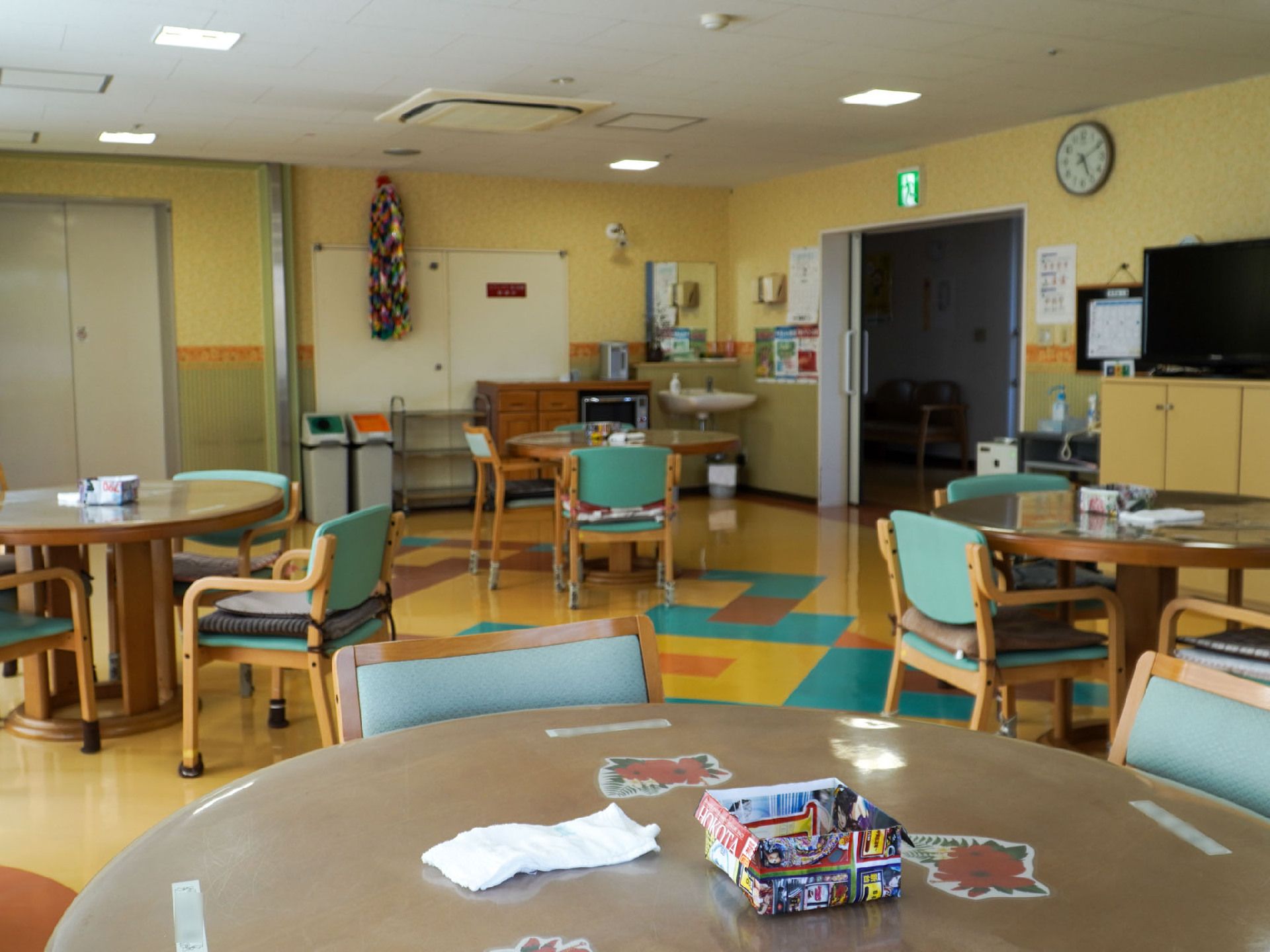 椅子に囲まれた丸テーブルが４つある部屋