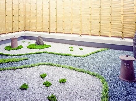 本格的な枯山水庭園風の庭には異なる色の砂利が敷かれ、竜の髭のような植物が線や模様を描いている。