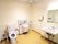 手すり付きの介護仕様のトイレがある広めのトイレスペース。立ち上がり用の手すりとオスメイトがある