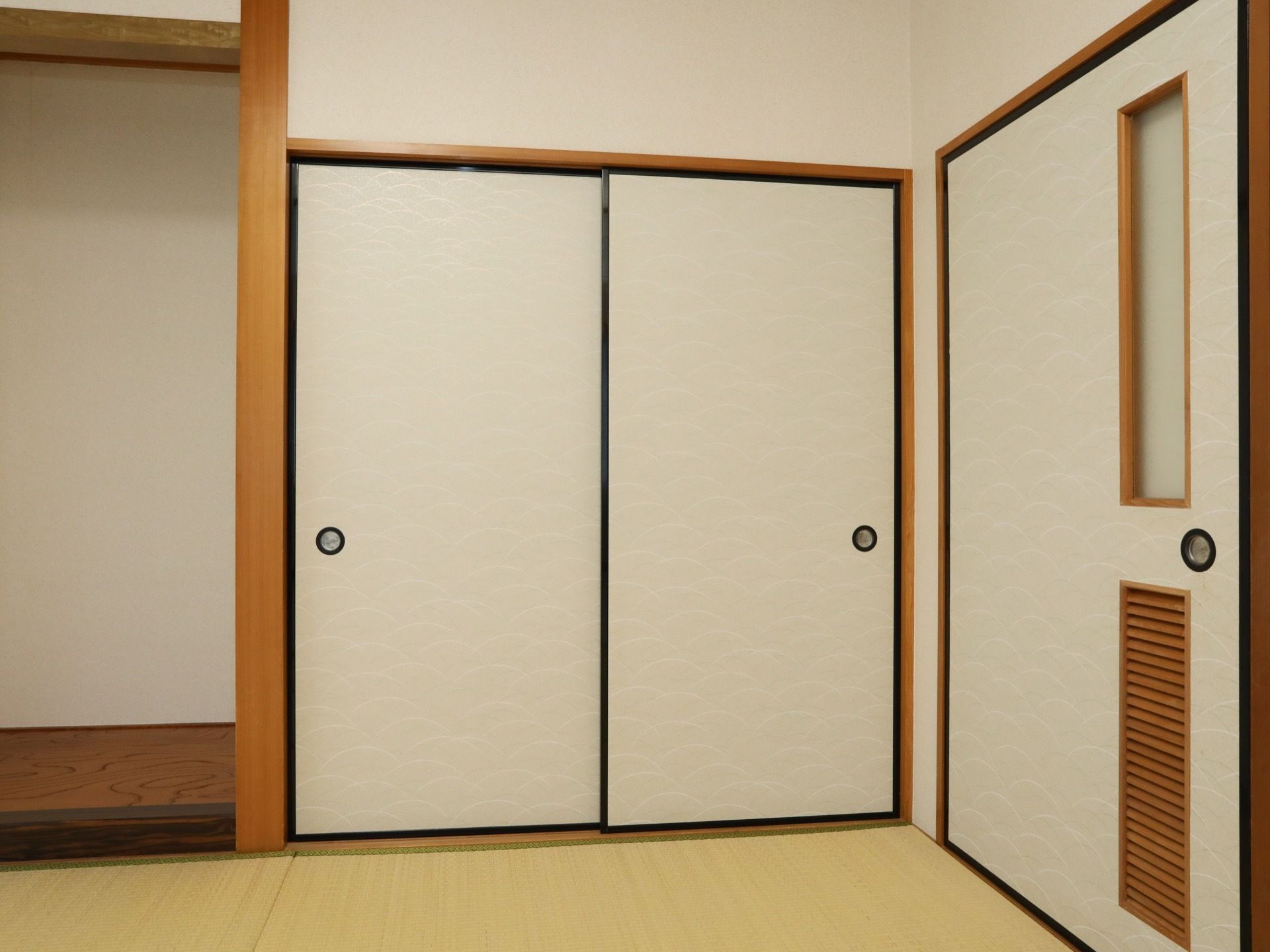 清潔感のある明るい和室で、床には畳が敷かれている。部屋の扉の近くには、大きな押し入れが備え付けられている。