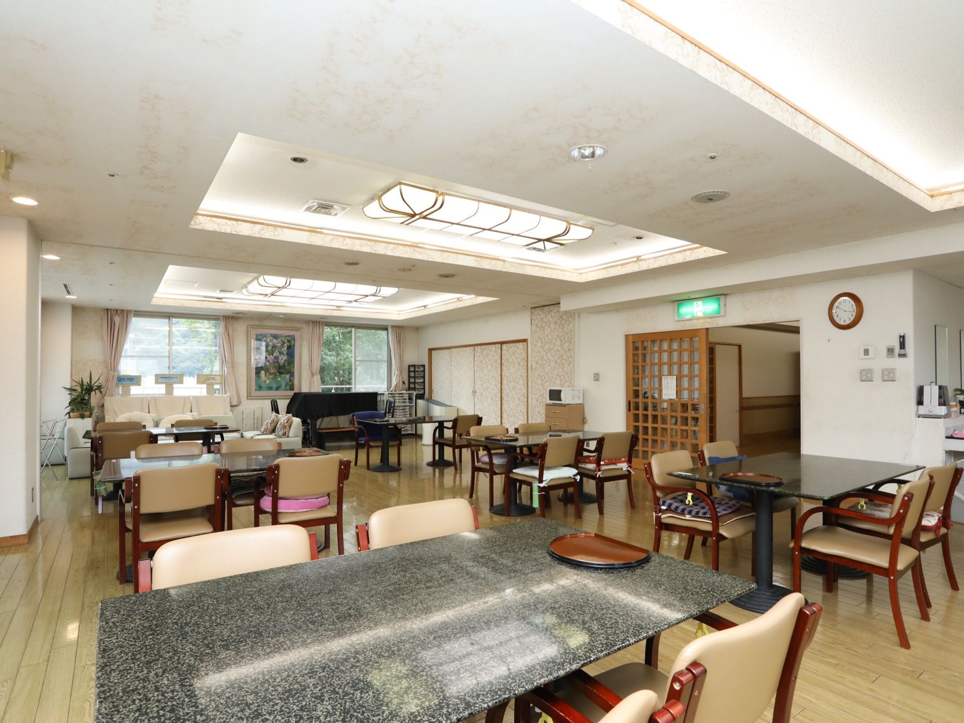 ピアノや椅子が用意されている食堂兼リビングスペースである。廊下との間は引き戸で仕切られており、上部の壁には非常口の表札が設置されている。