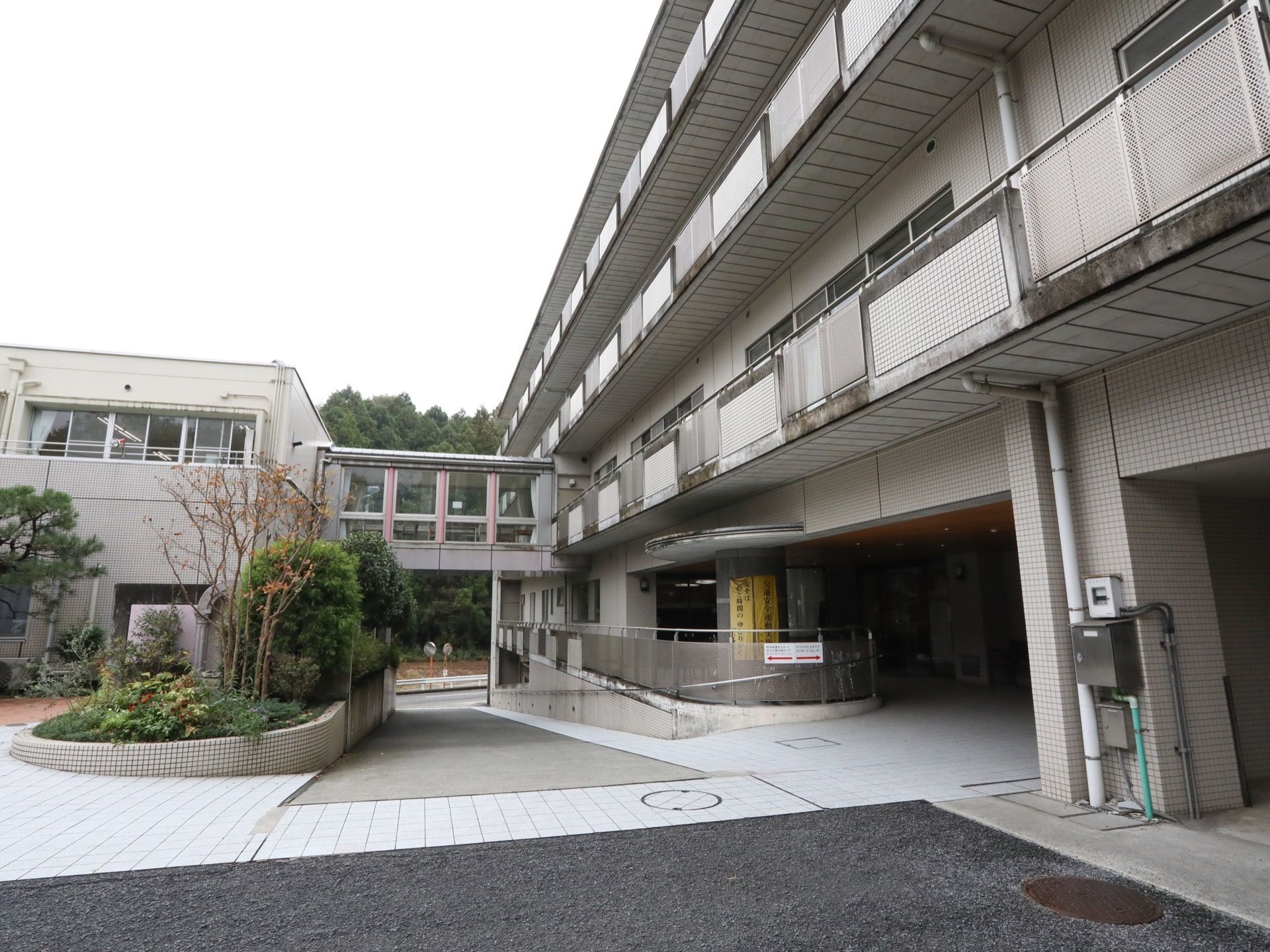 白を基調とした４階建ての建物で、２階部分に渡り廊下が設置されている。周辺は豊かな自然に恵まれている。