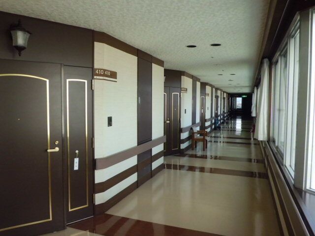 なにかを見ながら談笑しているスタッフと高齢者の様子。施設内の会話の場面