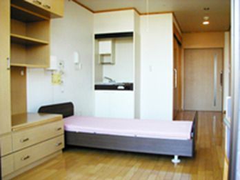 ベッドとキッチンがついた小さなワンルームの様子