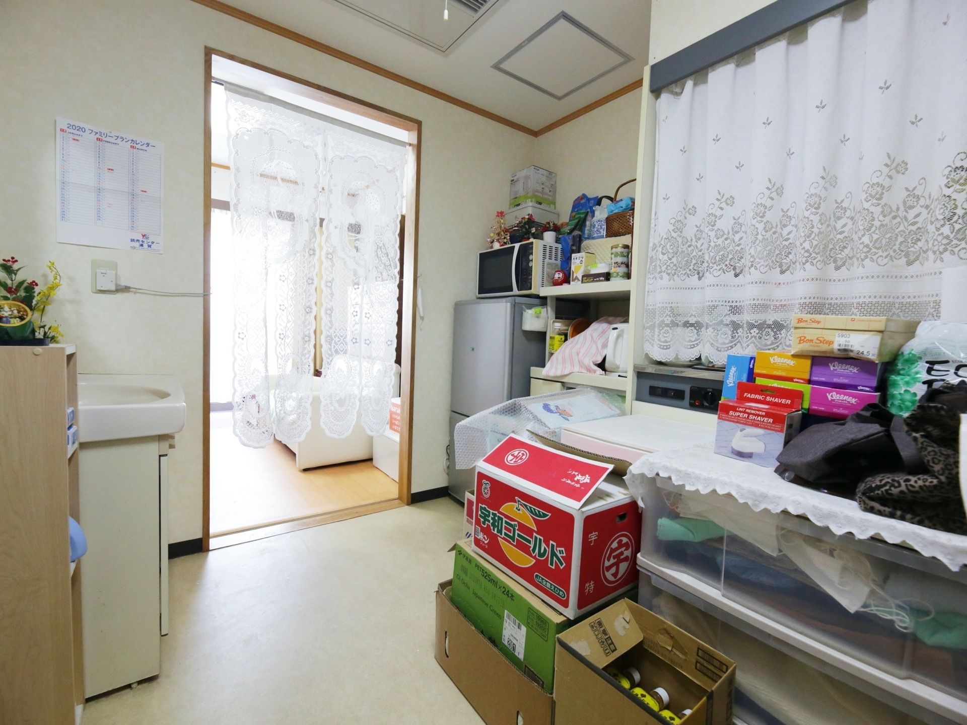 整理整頓が行き届いた個室の部屋である。調理家電や生活家電が揃っている。大きな窓からは日の光が差し込んでいる。