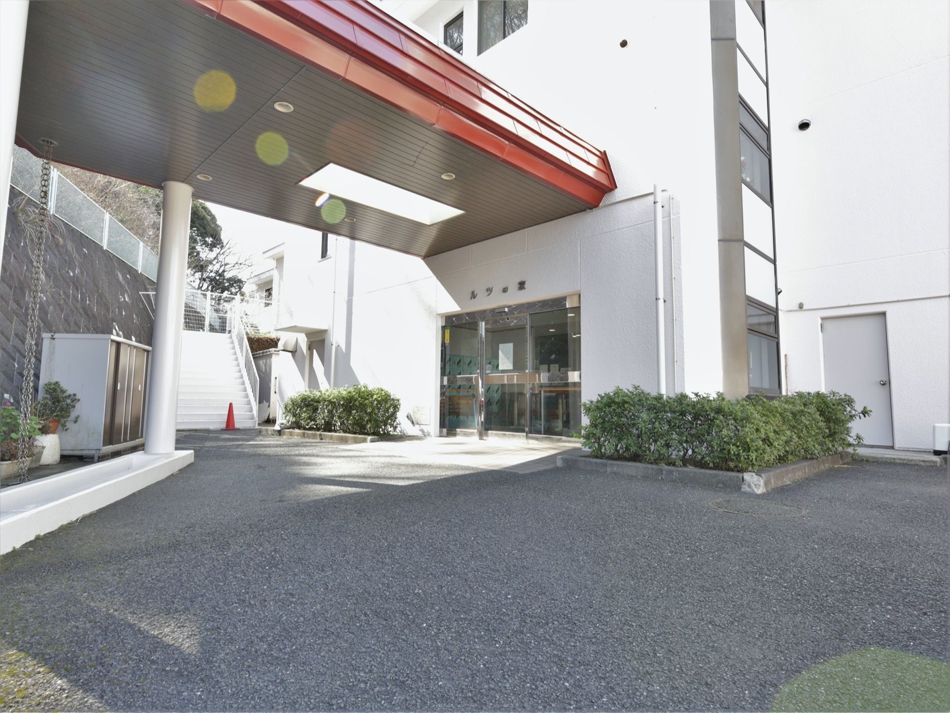 車寄せを完備した施設入口である。ゆとりあるスペースを設け、設置された自動扉の両サイドに植え込みが施されている。