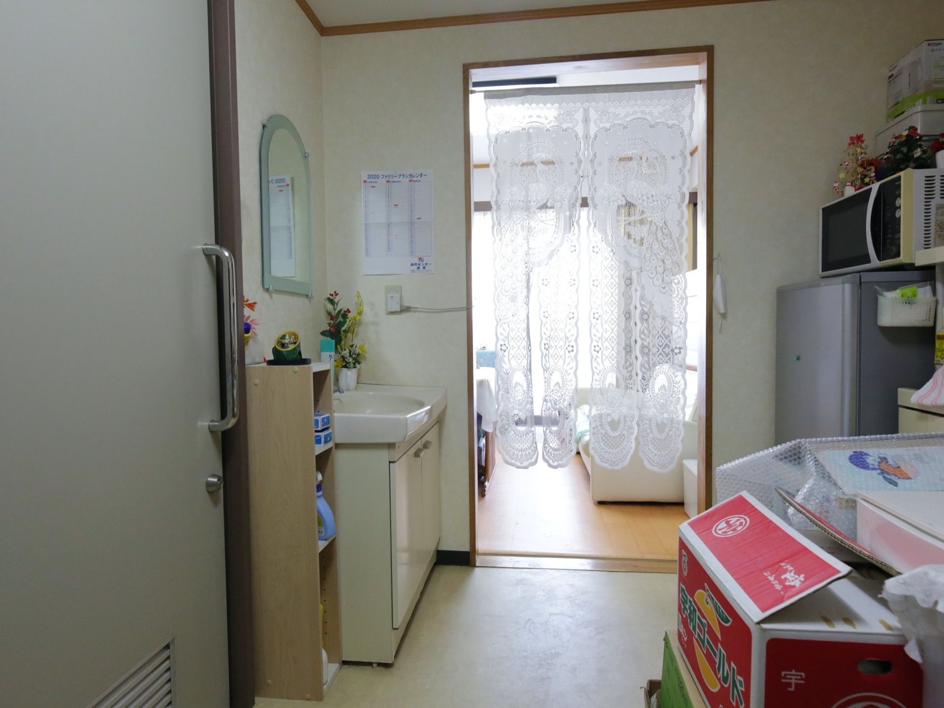 居室扉を背に内部を見た様子である。洗面台のそばの仕切り壁に開口部を設け、奥に完備されたフリースペースには、高さある窓が設置されている。