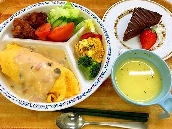 キノコソースがかかったオムレツや空揚げ、コーンスープにチョコレートケーキなどが並んだ食卓。