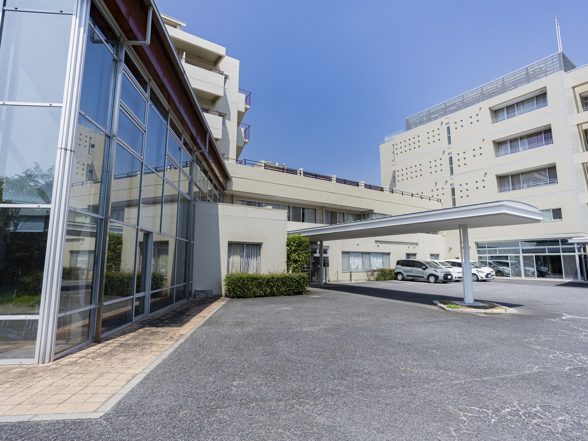 カメラに向かって笑顔を見せる車いすの女性とその家族、男女のスタッフの様子