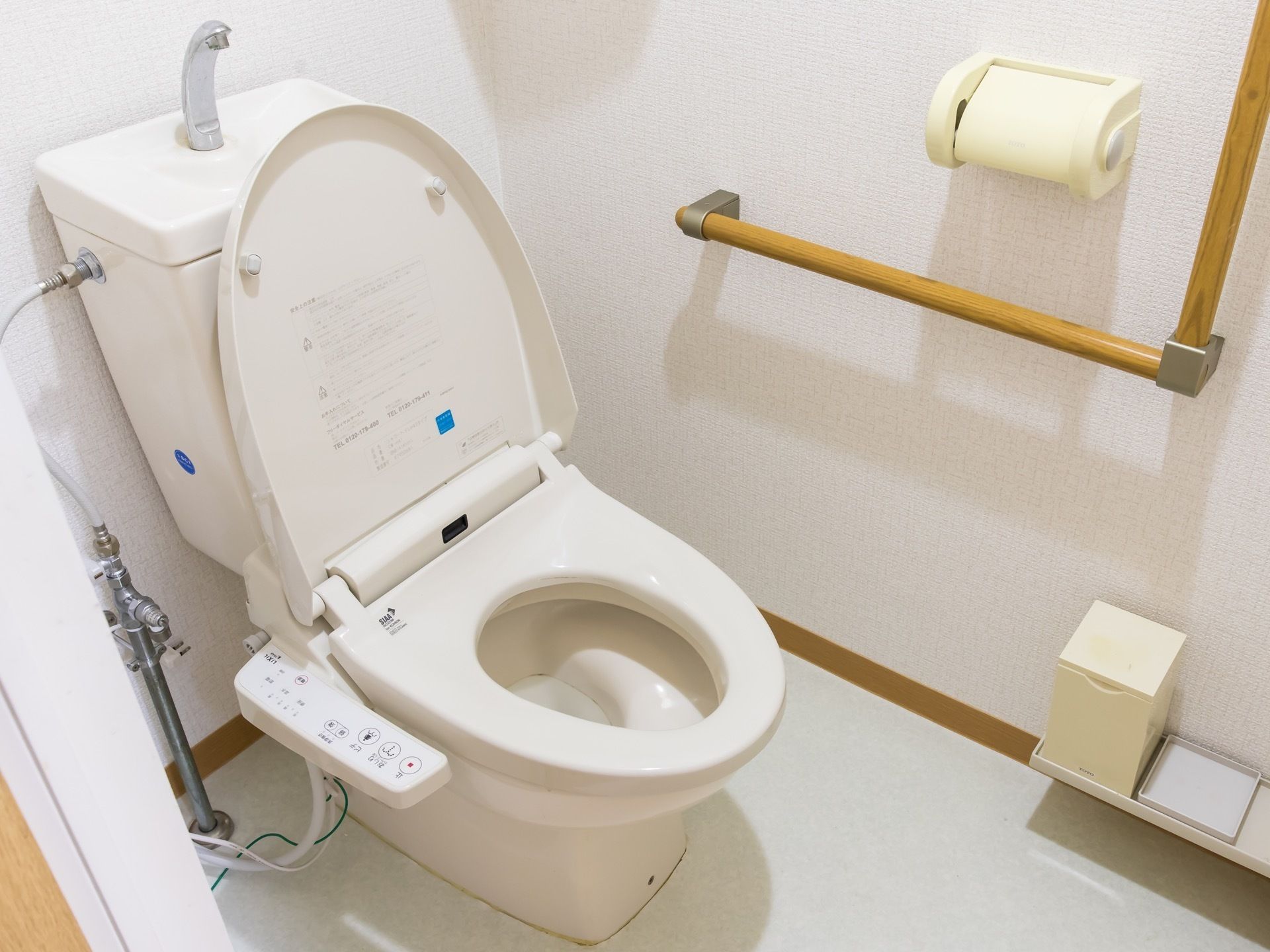 居室内のトイレには手洗いの付いた温水洗浄便座を採用している。L字型の手すりは、立ち居のふらつきをサポートしてくれる。