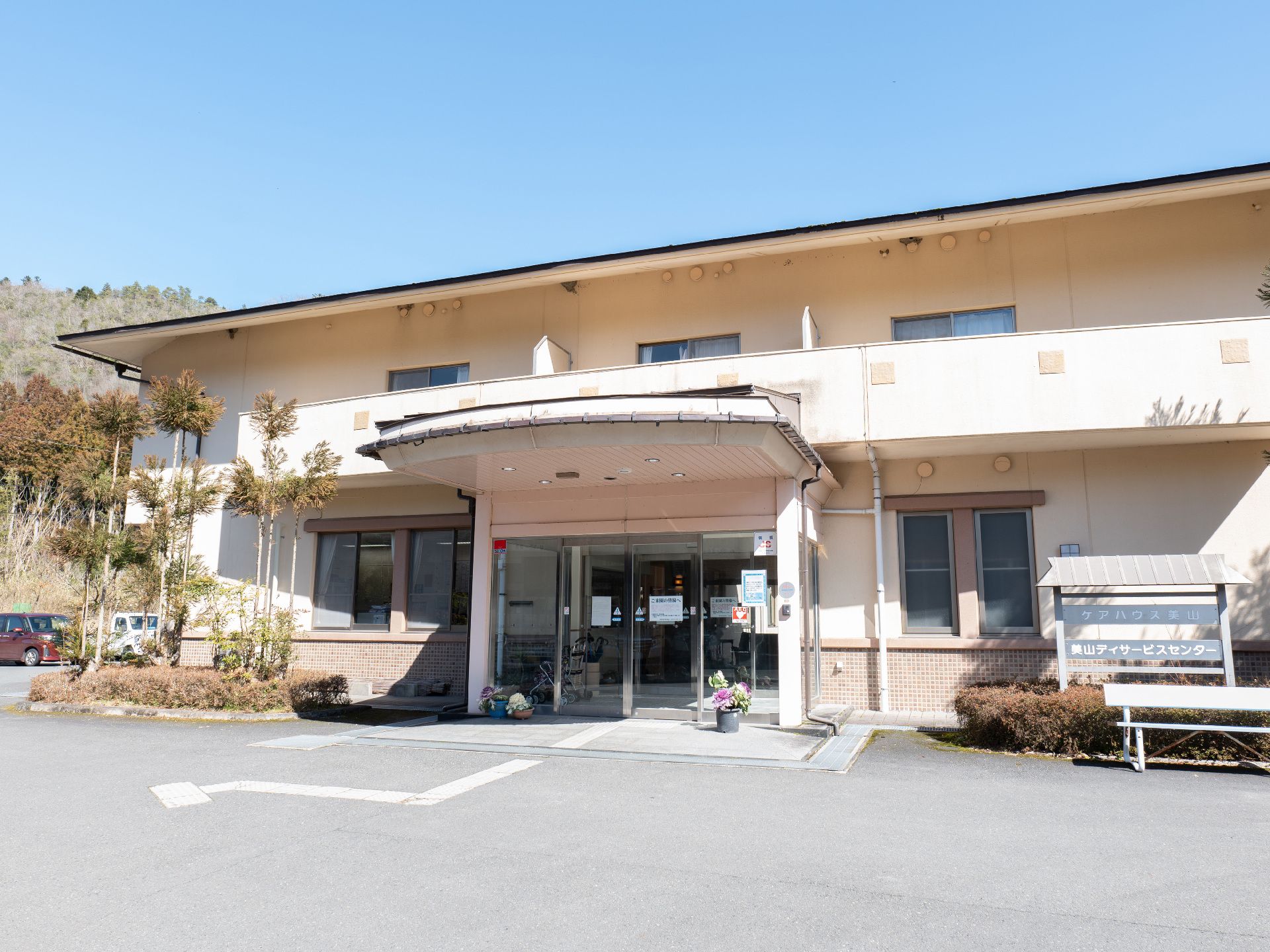 駐車場から撮影した２階建ての介護施設の外観