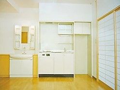 オールバリアフリーでフローリングの床の居室。ミニキッチンと収納棚があるのがわかる