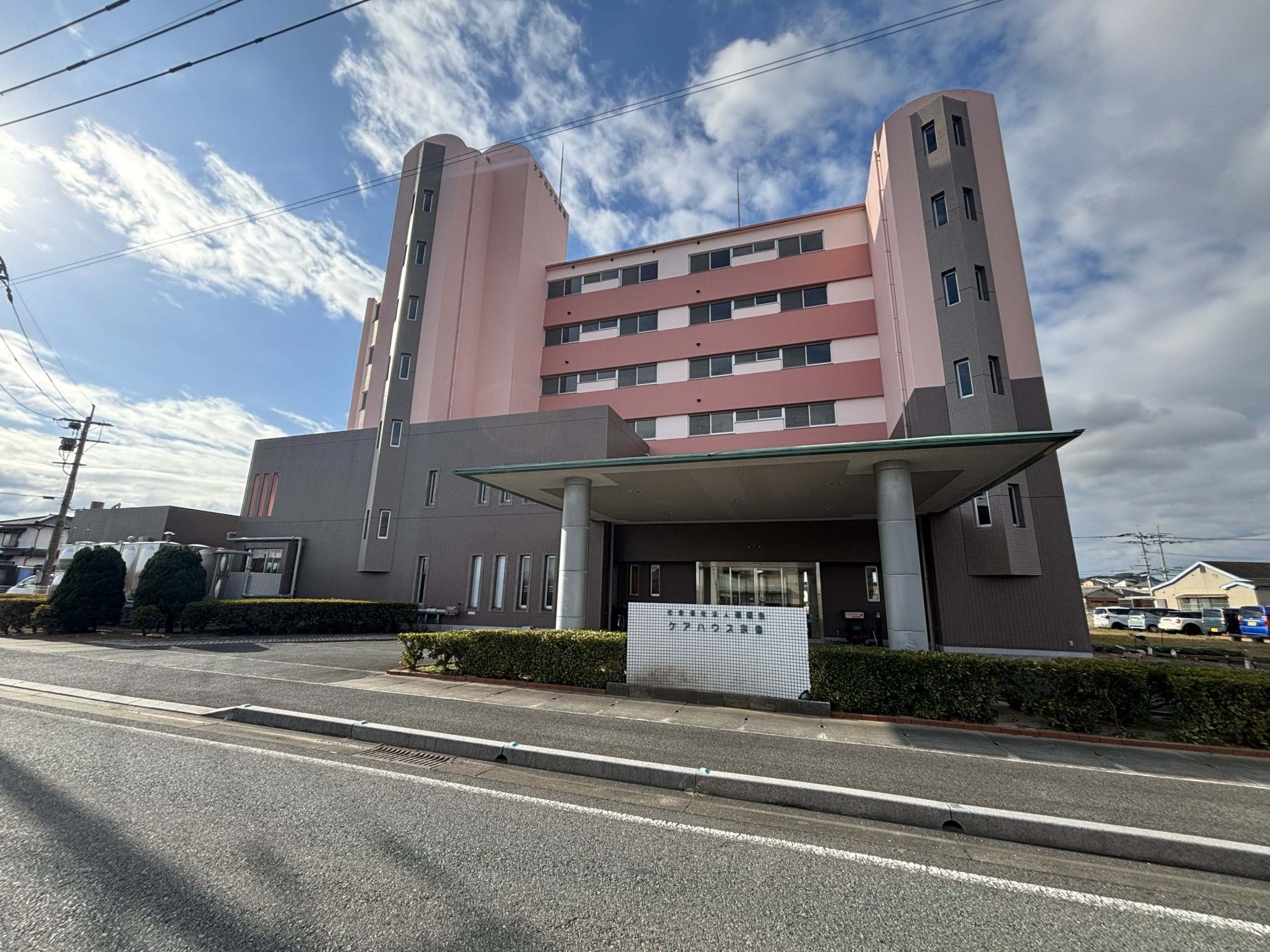 車椅子に乗った高齢女性の隣りに寄り添う女性ヘルパー