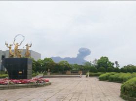 ブロックが敷かれた公園内には金の子どもの像もあり、その周りにはピンクや白の花が植えられている。