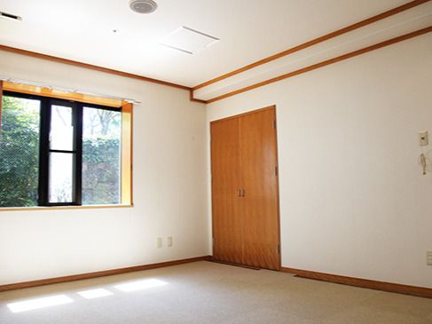 カーテンのない大きな窓が付いている部屋の壁には緊急通報装置があり、家具は置かれていない。