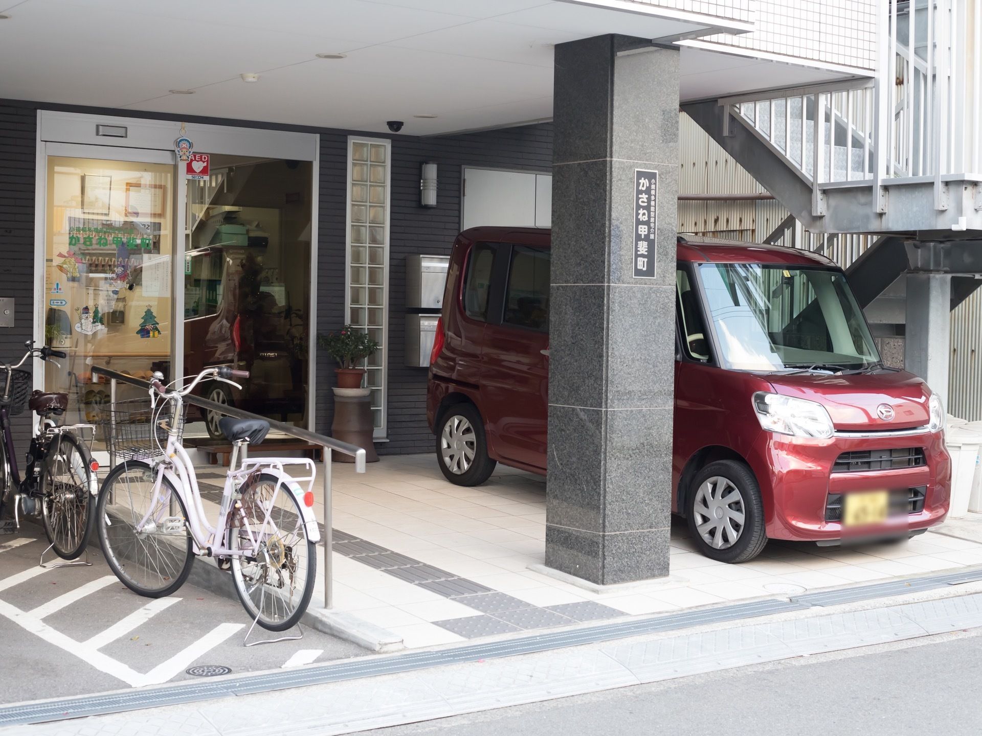 エントランスの通路には緩いスロープと手すりが設置されて、入居者様が安全に通行できるようになっている。