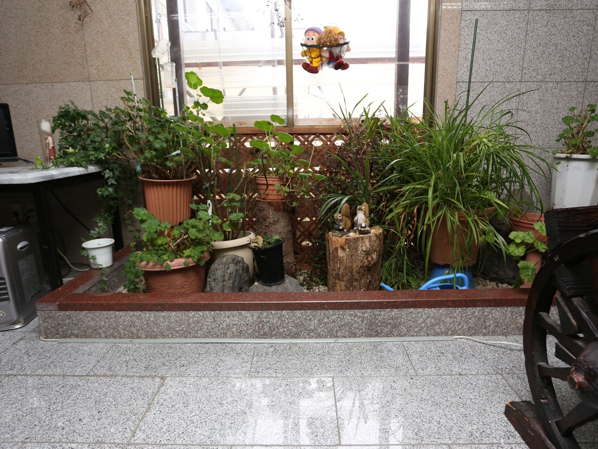 館内の一角に植物の鉢植えがたくさん置かれたコーナーが設けられている。バスケットに入った人形やリスの置物も飾られている。