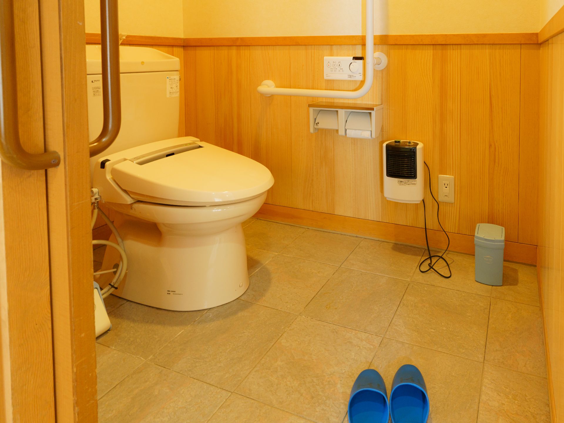 高齢者でも楽に座ることが可能な、手すりのついたトイレ