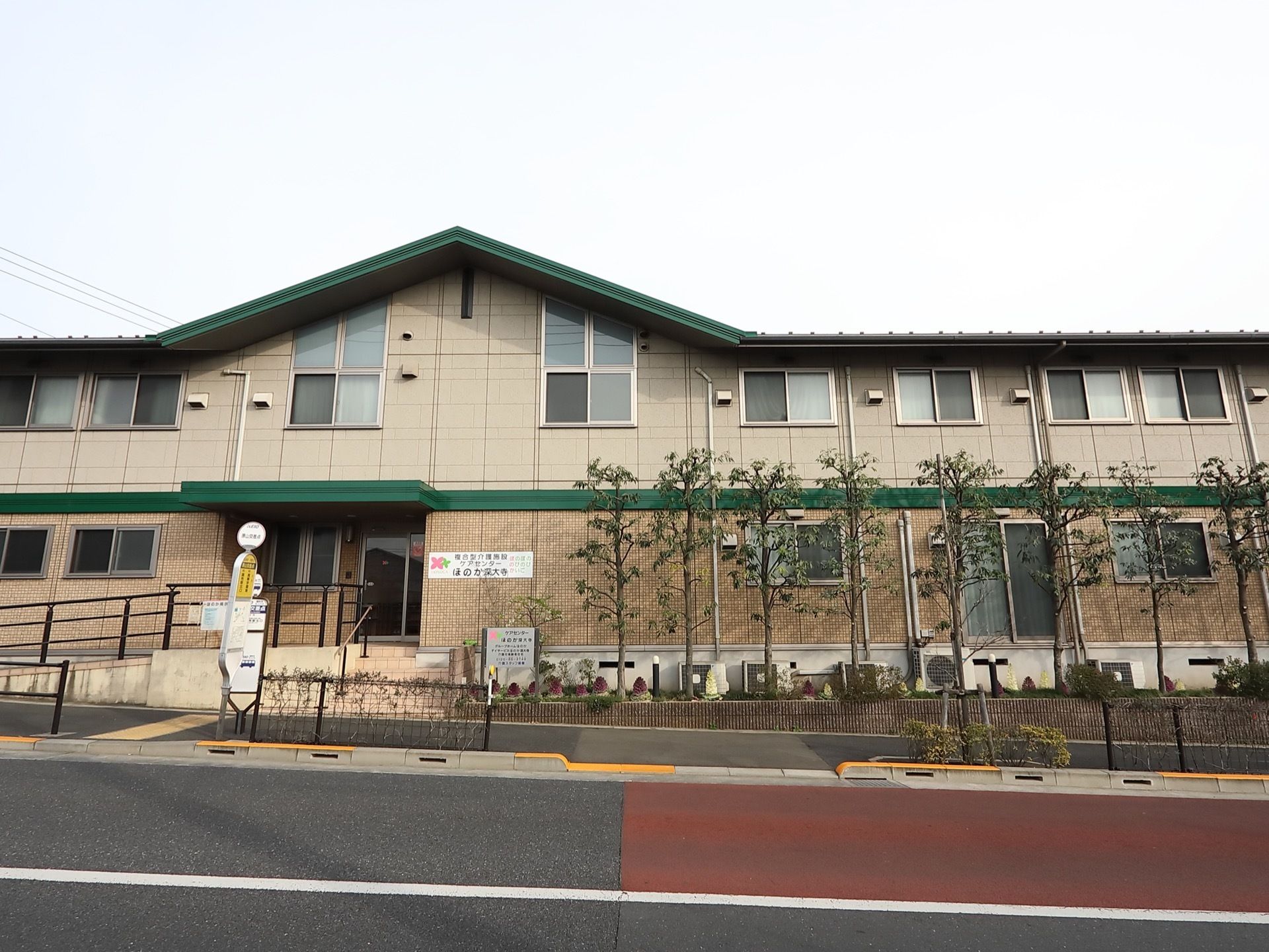 建物は２階建て。施設の前にはバス停があり外出しやすく、来訪者様もお越しいただきやすい。玄関前には緩やかなスロープが設置されている。