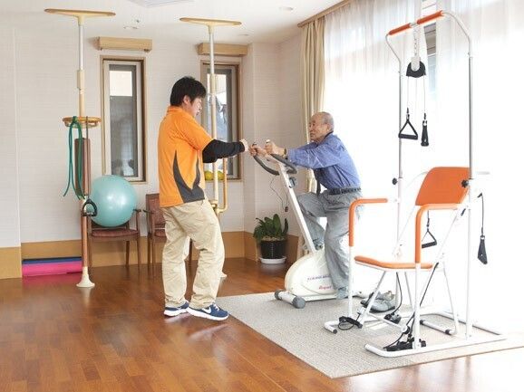 高齢者と一緒にカルテのようなものを眺めている施設内スタッフとの2ショット