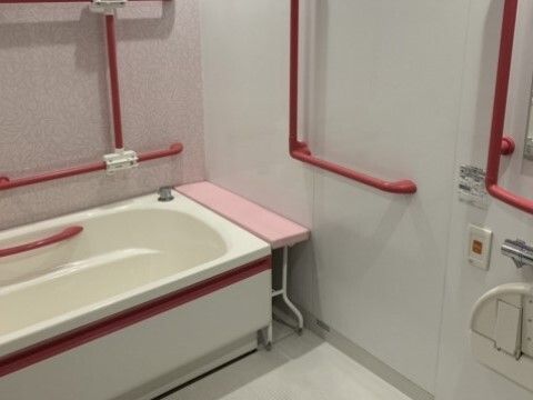 真っ赤な手すりがたくさん付いた浴室には呼び出しボタンが付き、洗い場も広く作られている。