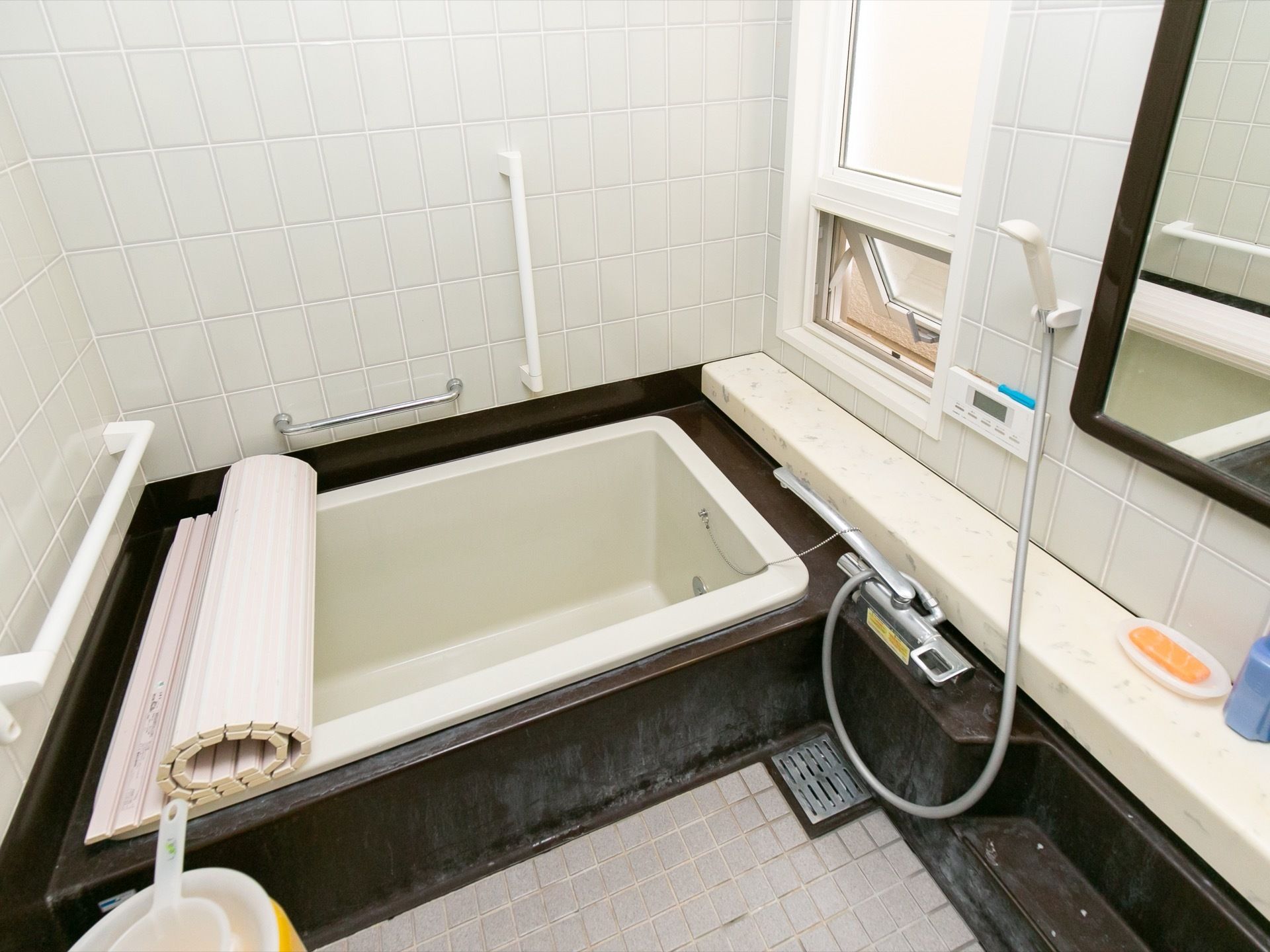 石材を多く使用した個浴用浴室である。手前に洗い場があり、壁にシャワーの操作パネルが付けられている。