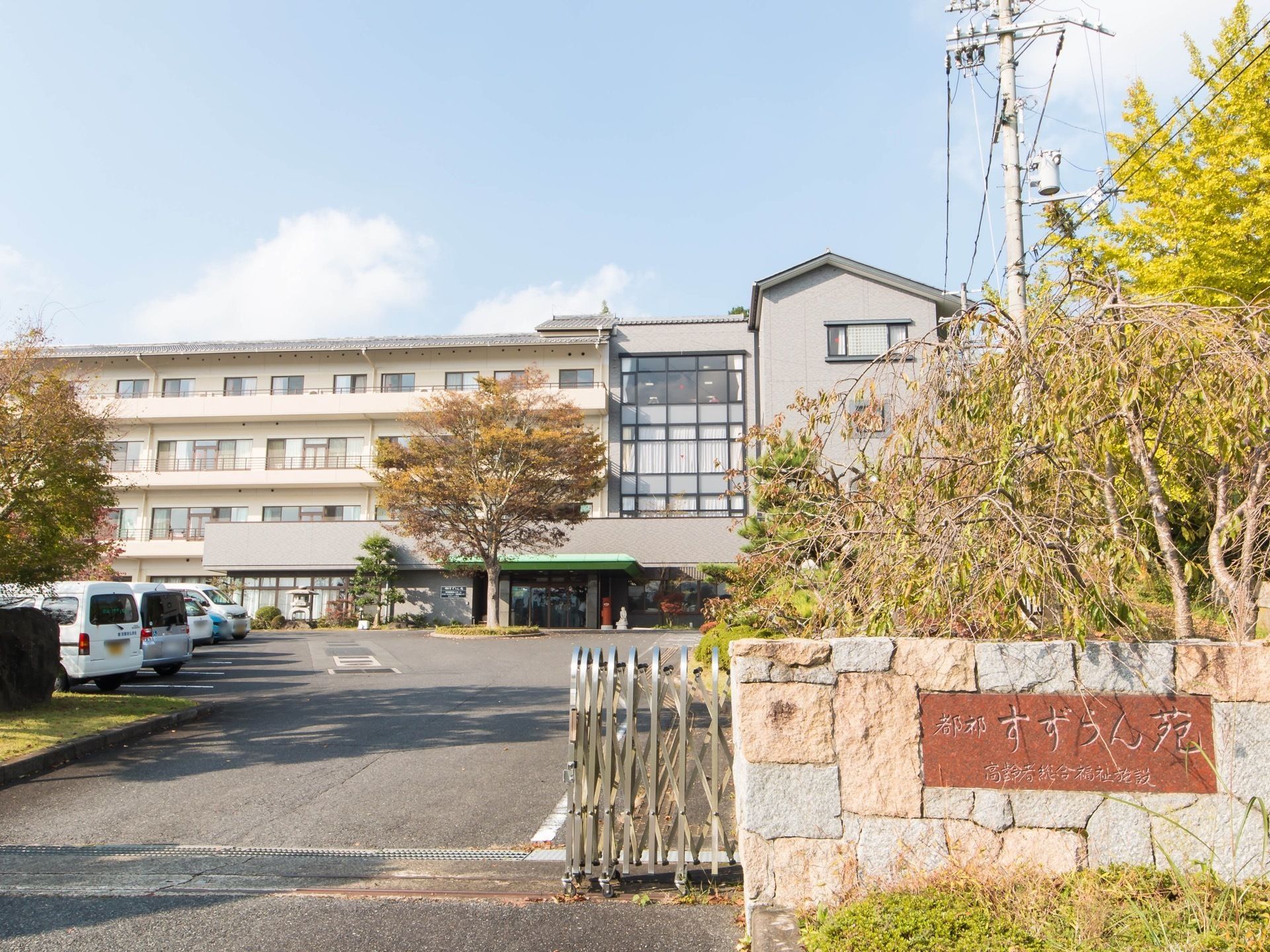 広い敷地に立地している施設である。石積みの門柱に、施設名称が彫りこまれた横長の表札が設置されている。