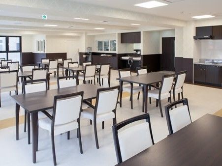 キッチンがある食堂には4人掛けのダイイングテーブルが複数置かれ、白と黒でまとめられすっきりとした印象。