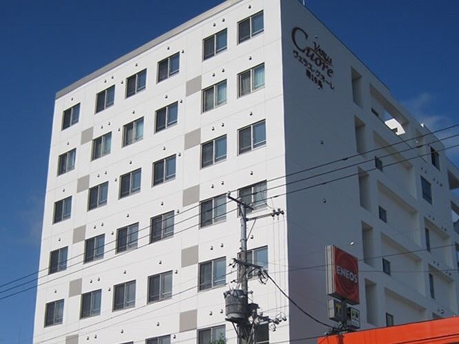 ホーム名が外壁に大きく書かれた建物は縦に長く、白を基調とした外観。周りには背の高い建物はなく、日当たり良好。