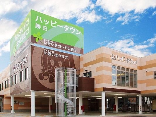 外壁には犬のイラストが描かれた２階建ての建物。ブラウン系で1階部分は駐車場がある。