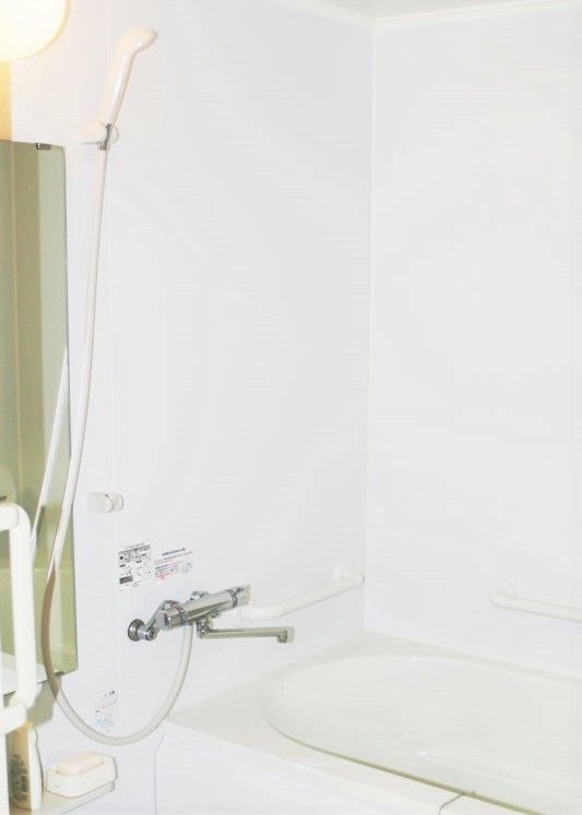家庭用サイズの浴室内に普通サイズの浴槽と一般的なシャワー設備がある様子