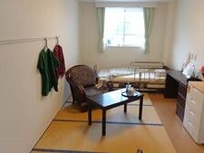 タンスがデスクセット、寝具付きのベッドが置かれた部屋には畳も敷かれている。