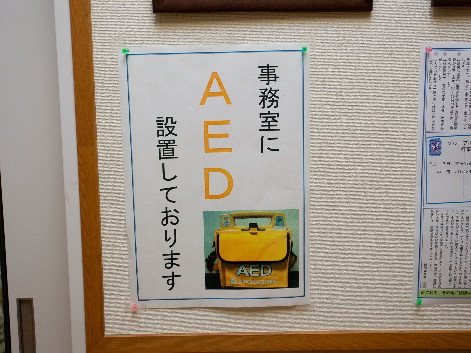 掲示板にお知らせが貼られている。緊急時に使用できるよう、事務室にAEDが設置されていることを知らせるプリントだ。