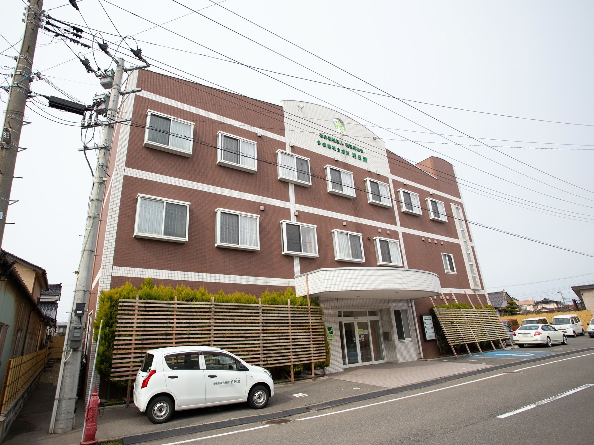 小豆色の壁に白いタイルが印象的な外観となっている。玄関には段差がなく、ドアのすぐそばに車を横付けすることもできる。