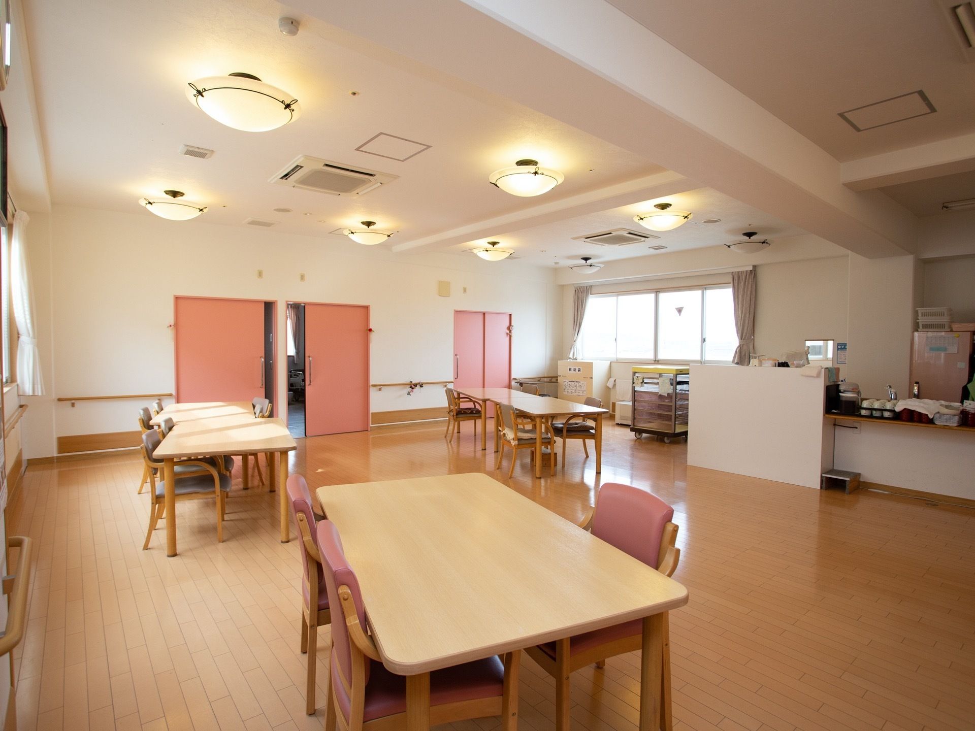 扉や椅子、冷蔵庫にピンクを取り入れた温かみのある食堂。移動にストレスがかからない広いスペースを確保している。
