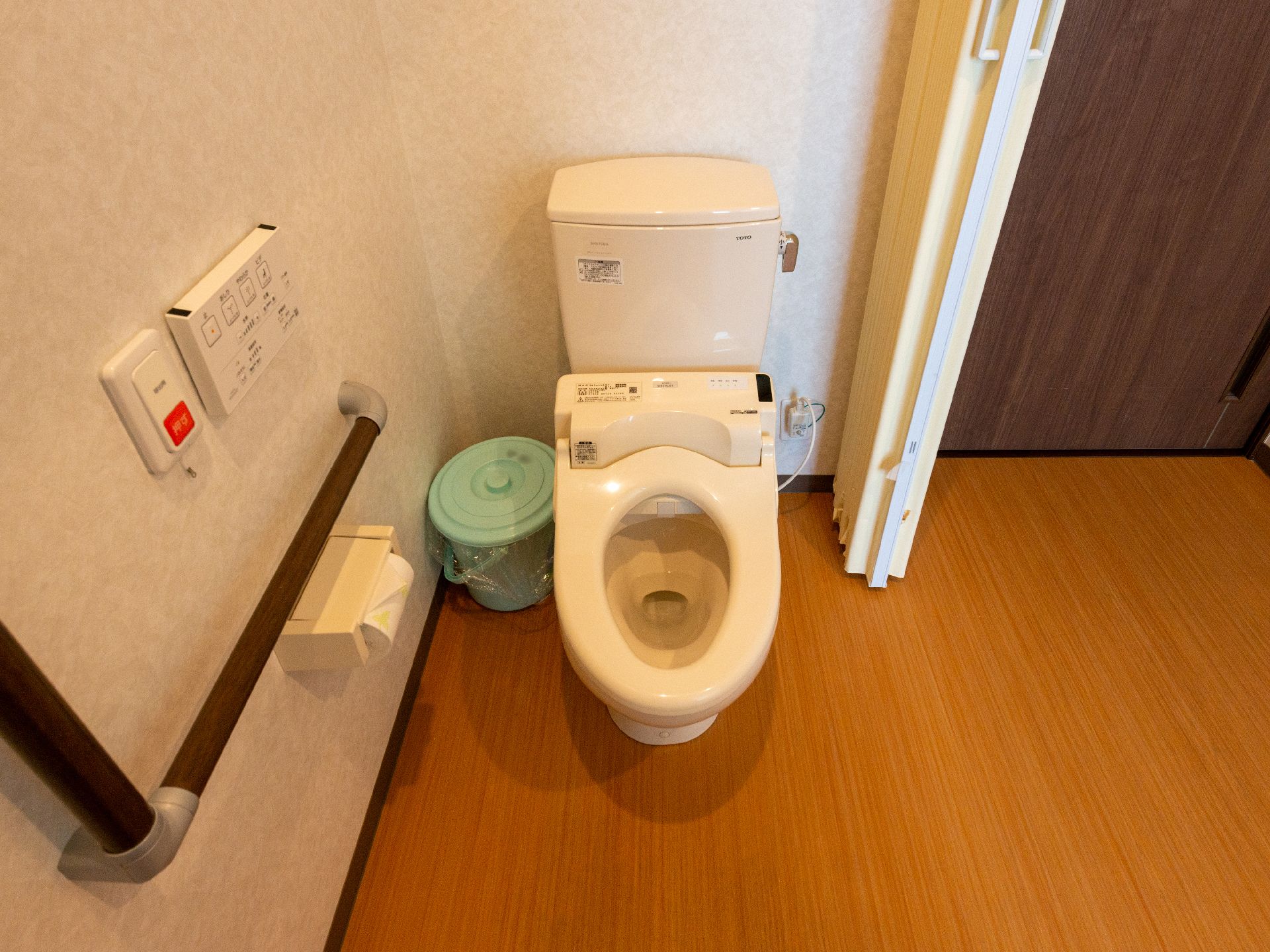 高齢者でも楽に座ることが可能な、手すりのついたトイレ