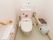 白を基調とした清潔感のあるトイレである。花のシールが貼られていて明るい雰囲気である。にぎりやすく工夫された手すりが備わっている。