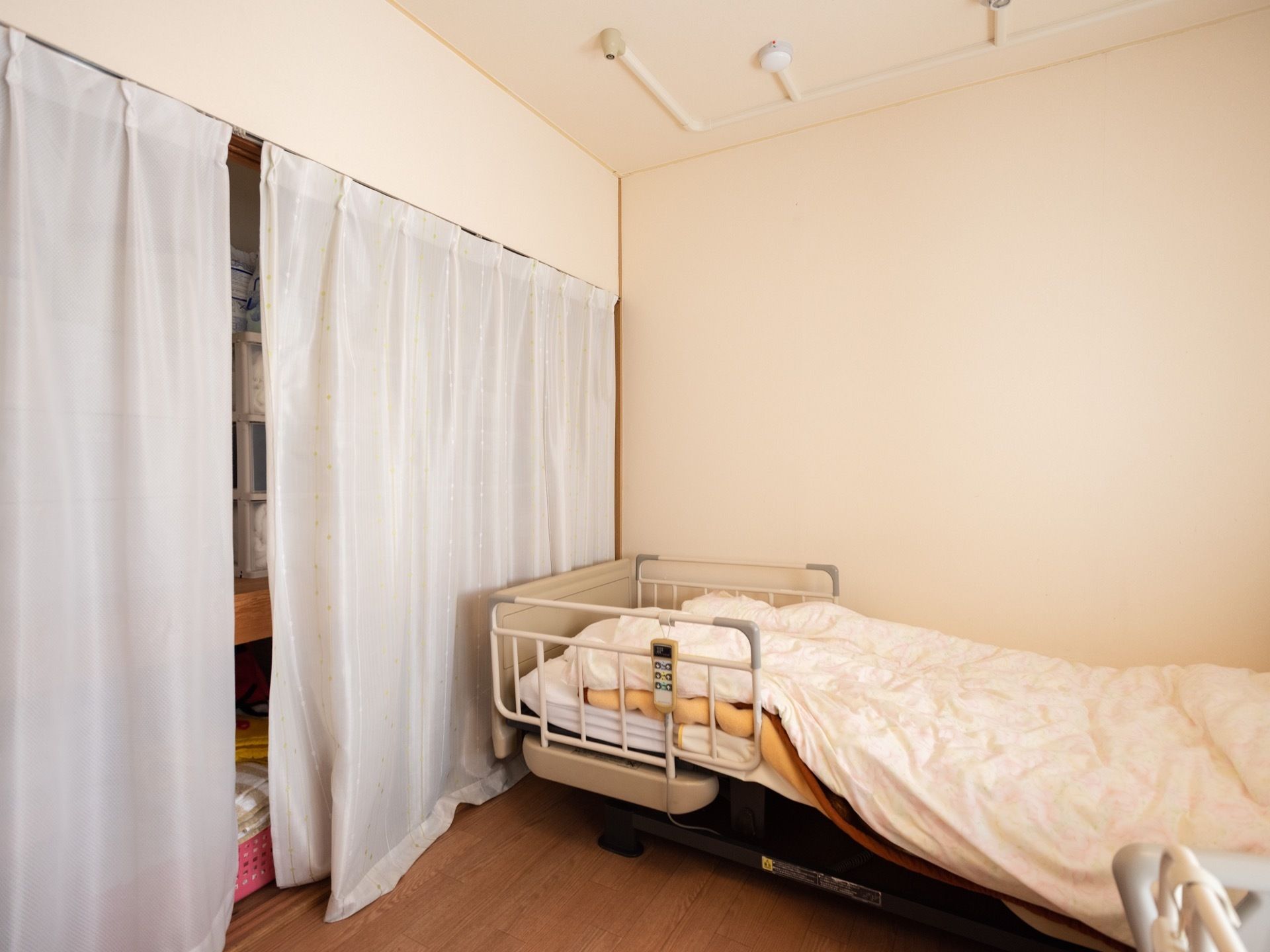 広々とした寝室には、介護用のベッドが置かれている。室内にクローゼットを配し、目隠し用のカーテンを用意している