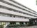 ５階建ての大きな建物は白でまとめられていてすっきりとした印象。玄関周りには緑が多い。