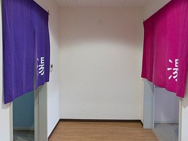右側には赤紫の暖簾がかかり、左側には青い暖簾がかかっていて、それぞれ「湯」を書かれている。