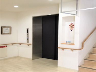 階段とエレベーターが並んで設置されていて、エレベーターの横には操作ボタンがあり、フロアには余計なものは置かれていない。
