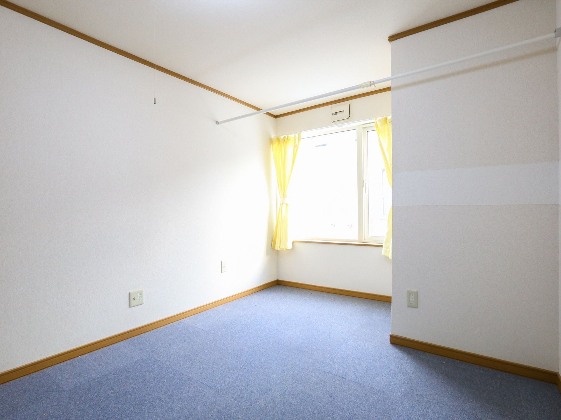 部屋の奥には大きな窓があり、部屋に自然光が良く入るように設計されている。白く清潔感のある内装で部屋は統一されている。