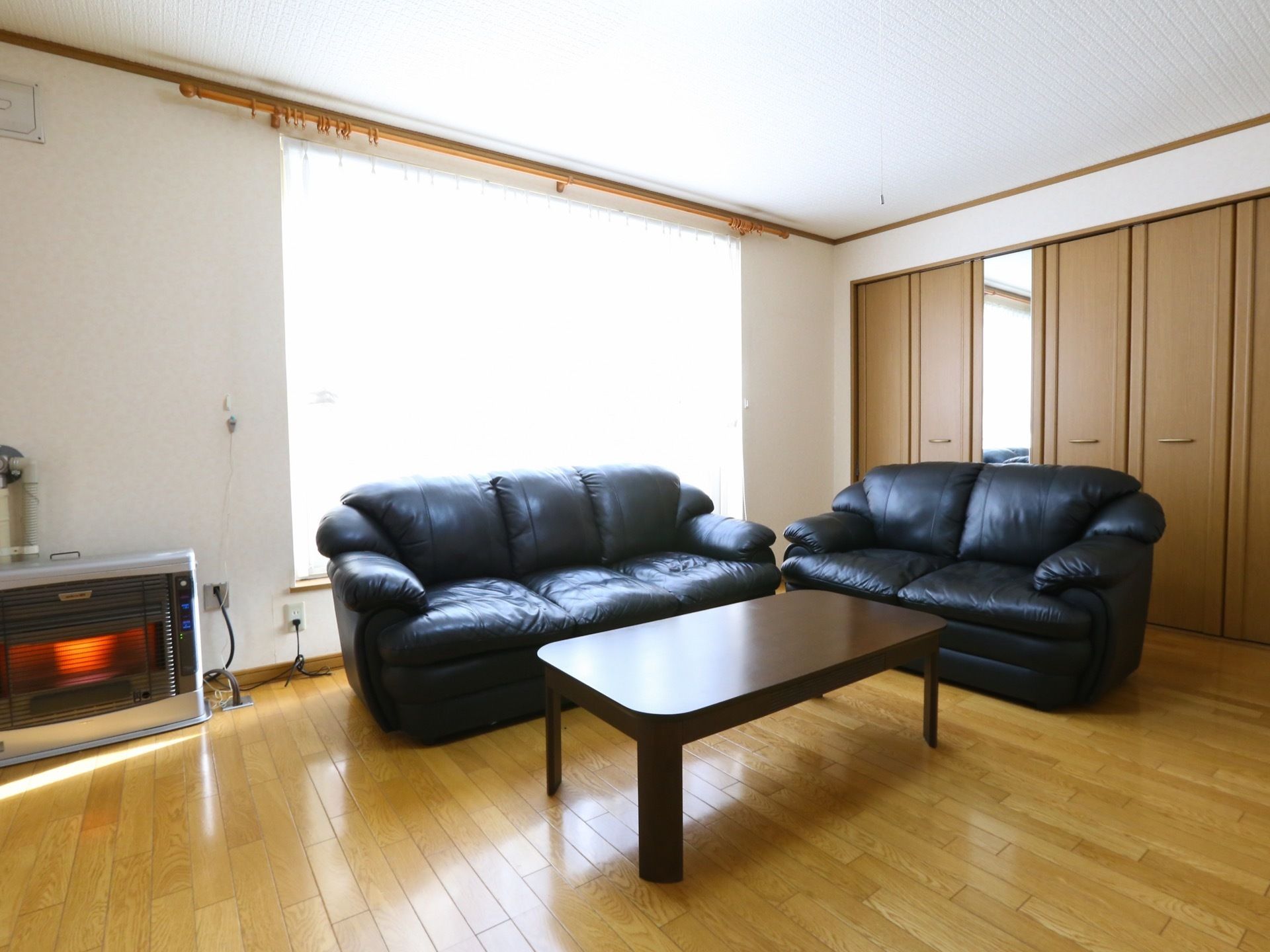 ダイニングと続き部屋になった広々としたリビングには、革張りの大きなソファとテーブルが設置されている。