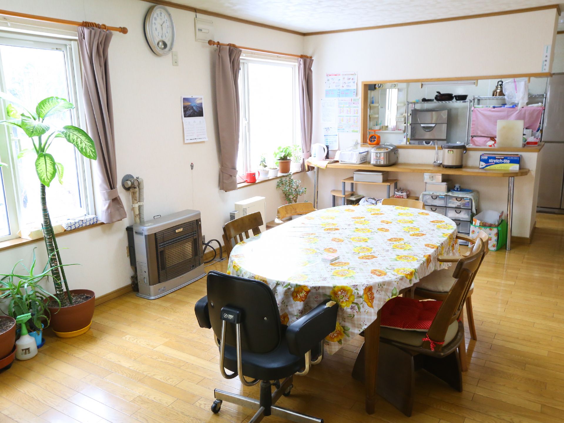 左に2つの窓、正面にカウンターがあり、楕円形のテーブルが置かれた食堂