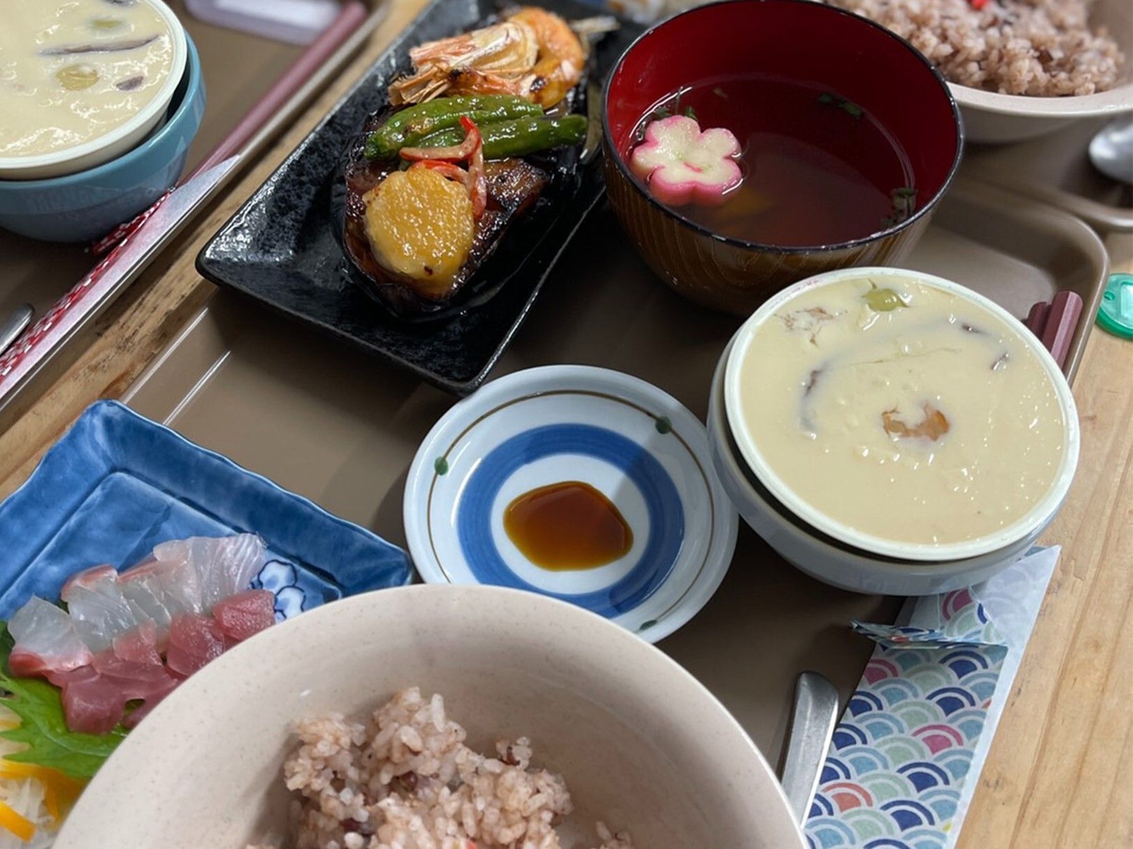 刺身や野菜の煮物、赤飯セットになった食事