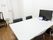 部屋には、白いテーブルが置いてあり、椅子を2脚ずつ向かい合うように配置している。テーブルの上には、パソコンと小さな卓上カレンダーがある。