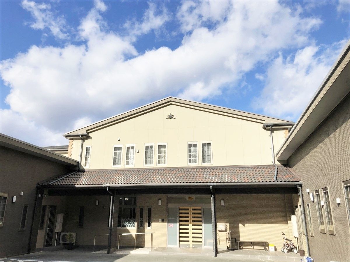 小さな窓がある大きな一軒家風の建物。住宅型ホームナーシング伊勢の外観